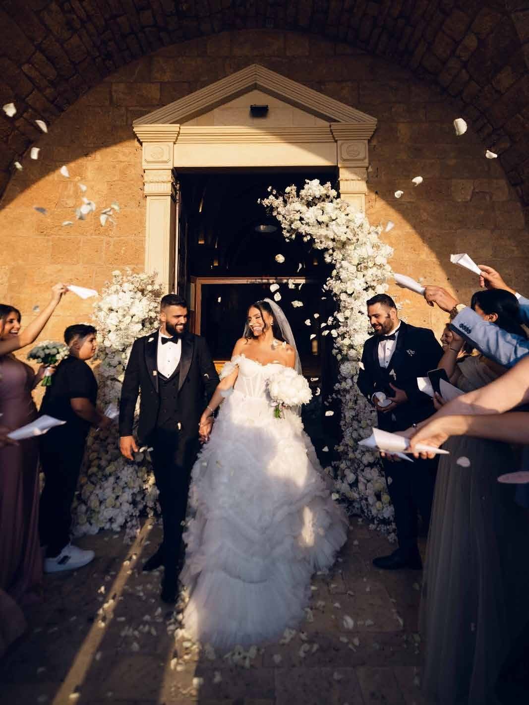 The couple leaving the church beneath a shower of petals